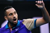 Nick Kyrgios opens his mouth and raises his left arm