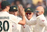 Australian male Test players celebrate Indian wicket.