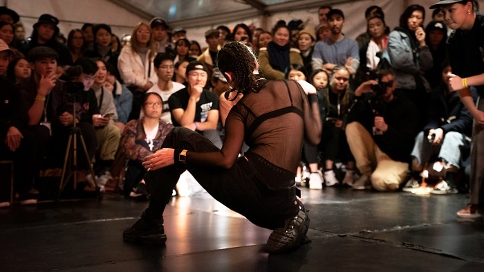 A female breakdancer performs for the crowd