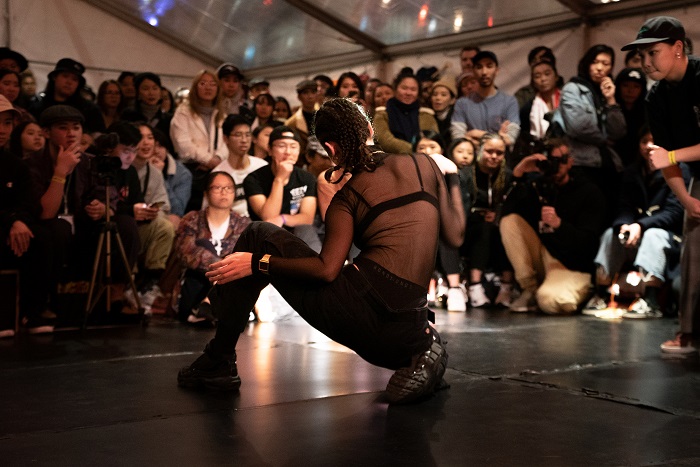 A female breakdancer performs for the crowd