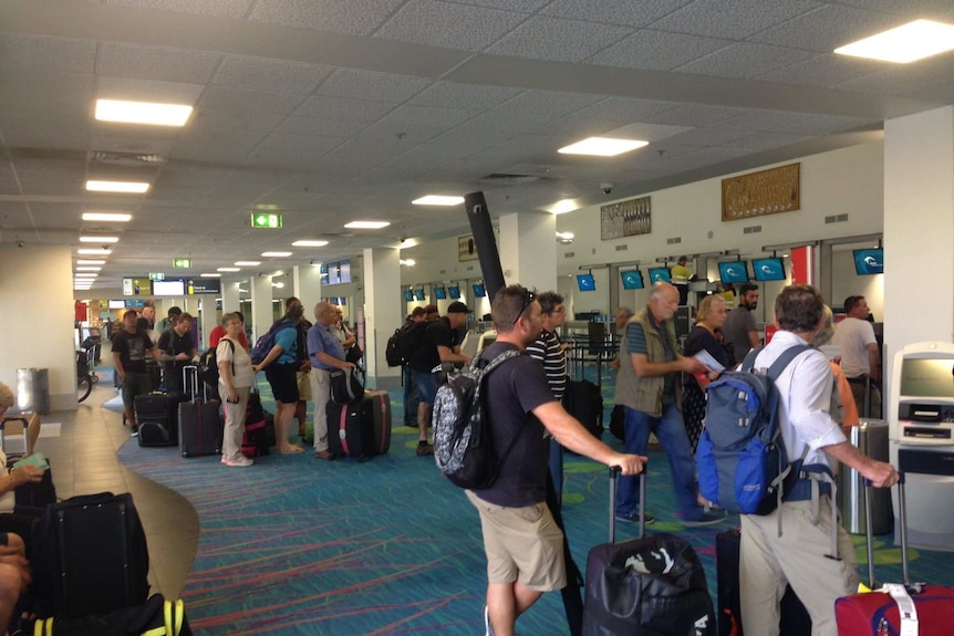Inpex workers line up at the airport check in areas.