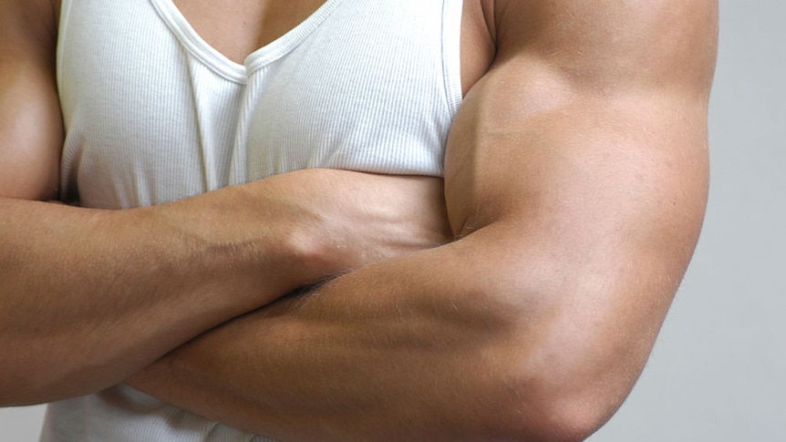 A muscular man in a white singlet