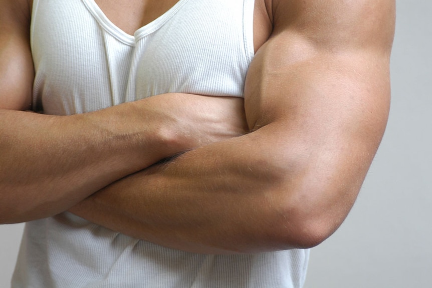 A muscular man in a white singlet