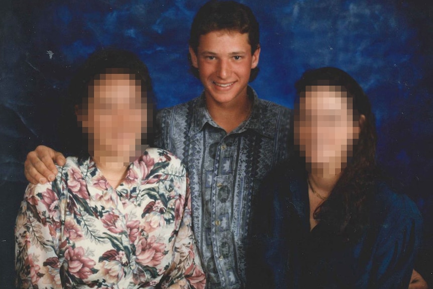 A teenage boy with his two sisters. The girls' faces are pixelated.