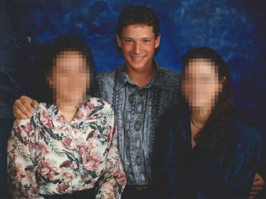 A teenage boy with his two sisters. The girls' faces are pixelated.