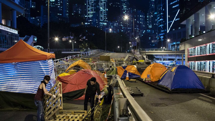 Pro-democracy protesters block a main road in Hong Kong's financial district with barricades and tents