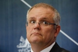 Scot Morrison glances to his left, with a tight-lipped expression on his face and raised eyebrows.