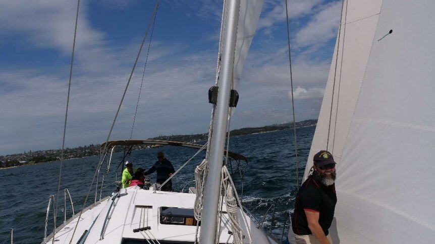 Adrian Whitby on the fore deck of Isa Lei yacht on Sydney Harbour.