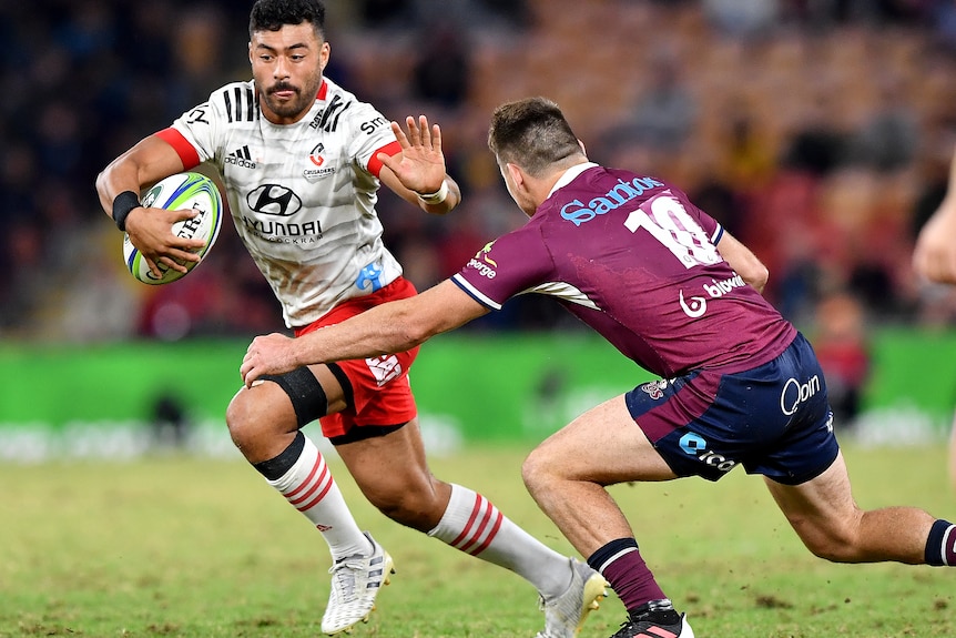 Richie Mo'unga puts out a hand as he shrugs off James O'Connor