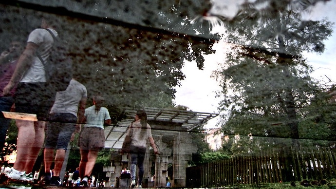 A distorted image shows a few un-identified kids wearing backpacks walking outside of school.