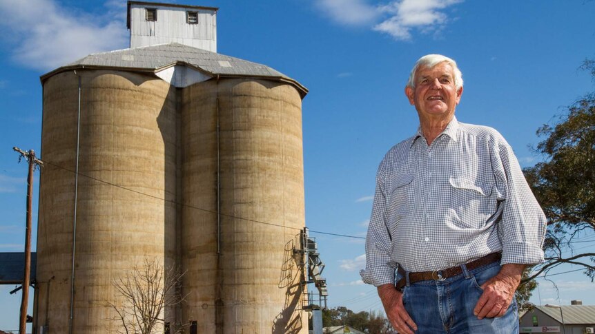 A man standing in front of an old concrete silo