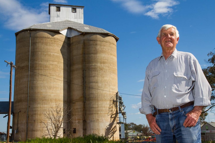 A man standing in front of an old concrete silo