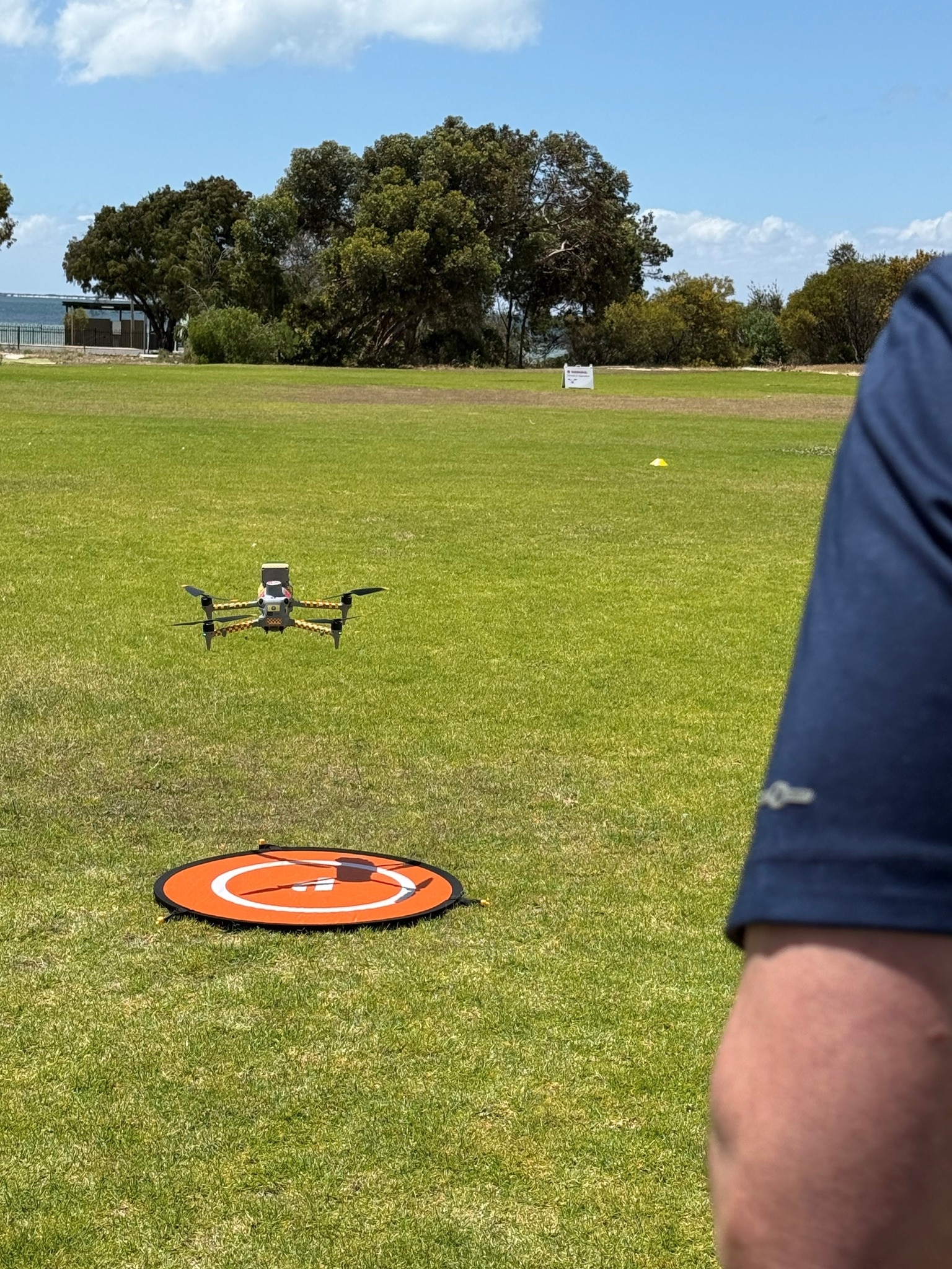 Un dron se cierne sobre una pista de aterrizaje sobre un poco de hierba.