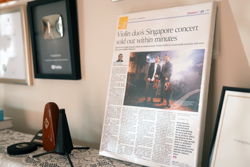 A newspaper article with the headline Violin duo's Singapore concert sold out within minutes, printed on canvas.