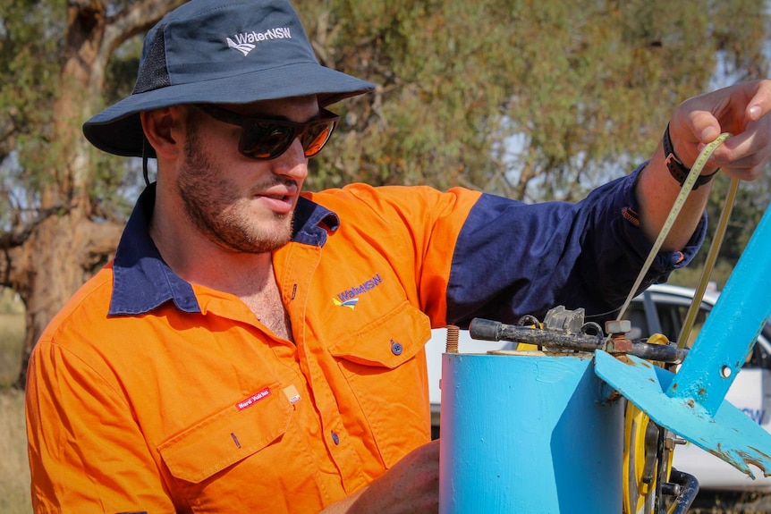 Water NSW hydrometric officer, Chris Ulvr-Green checks the depth of a monitoring bore.