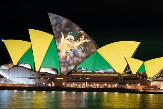 The green and gold of Australian sport is projected onto the sails of the Sydney Opera House.