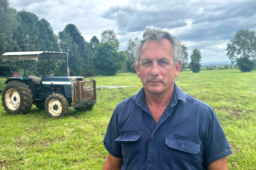 Gary Duffy in a paddock with a tractor nearby.