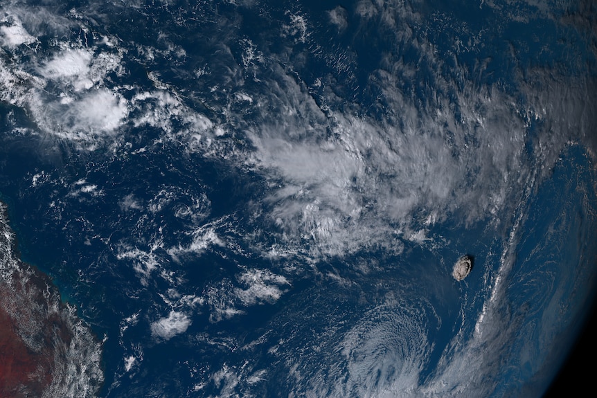 The satellite image shows an expanding cloud of smoke and ash in the middle of the ocean.