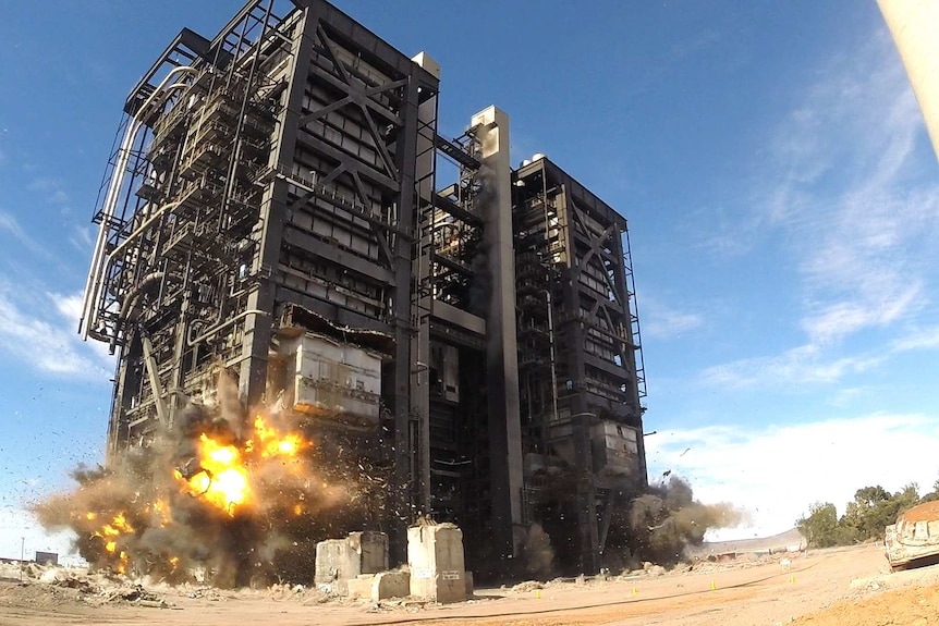 A huge industrial structure in the process of being destroyed with explosives.