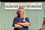 A blonde women stands with crossed arms in from of Bunbury Volunteer Bush Fire Brigade station.