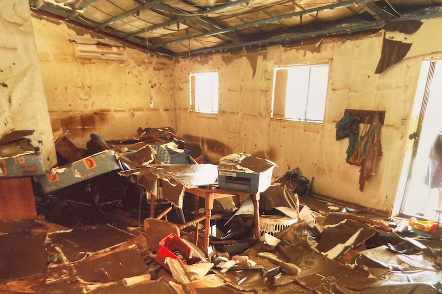 Inside a living room with mud and debris everywhere.
