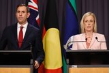 Jim Chalmers and Katy Gallagher stand behind podiums at a press conference in an indoor room