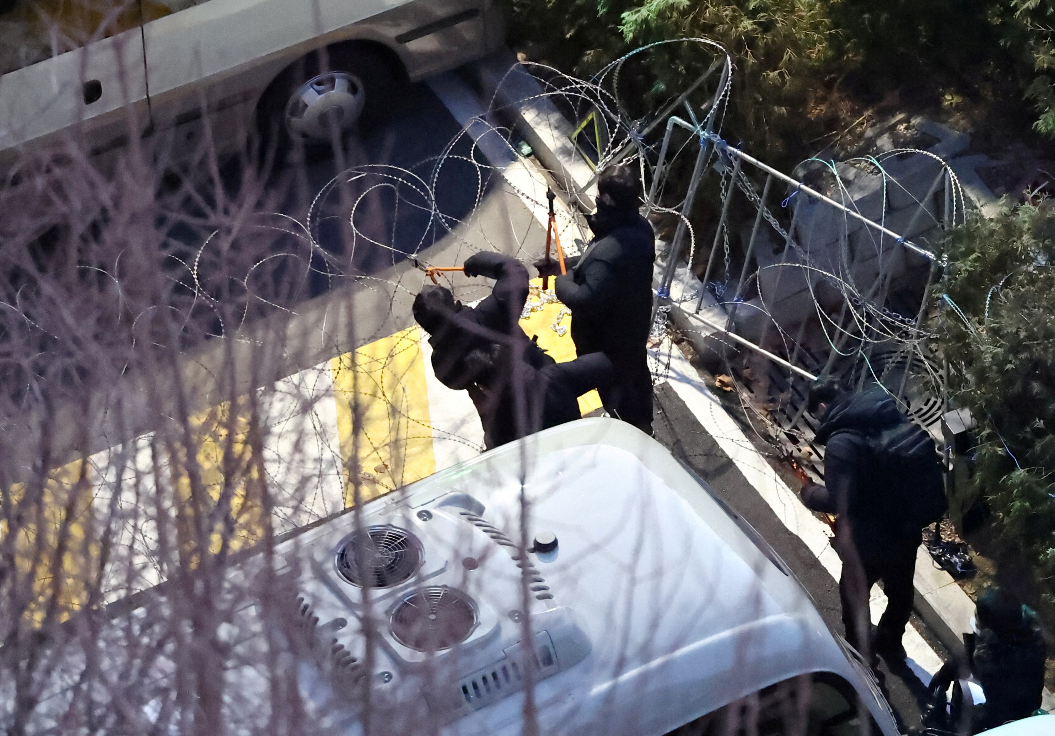 경찰이 윤석열 대통령 관저 입구에 설치된 철조망을 자르고 있다.