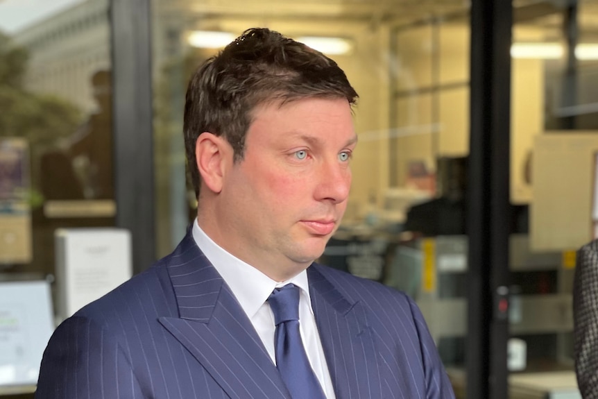 Victorian Liberal MP Tim Smith has a solemn expression as he holds a media conference outside a building