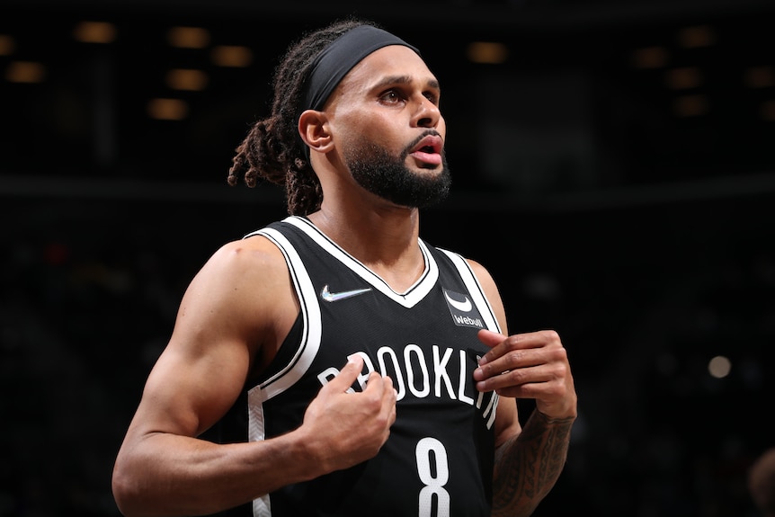 A Brooklyn Nets NBA player puts his hands to his chest during a game.