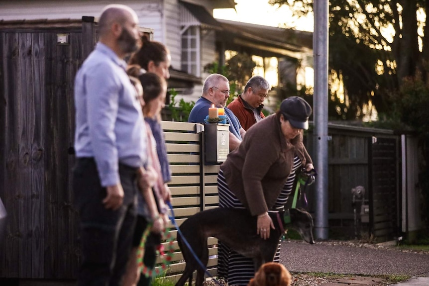 Residents line up for a driveway vigil shortly after dawn