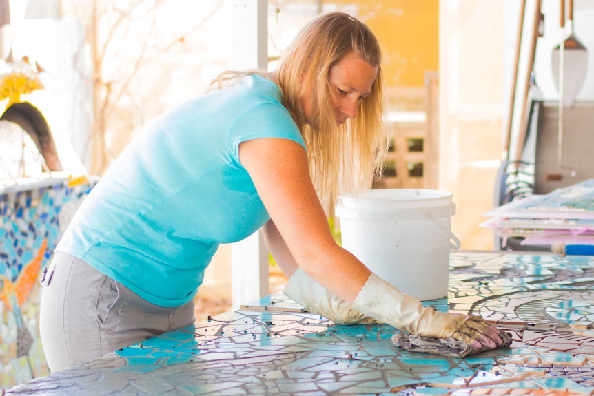 woman wiping mosaic