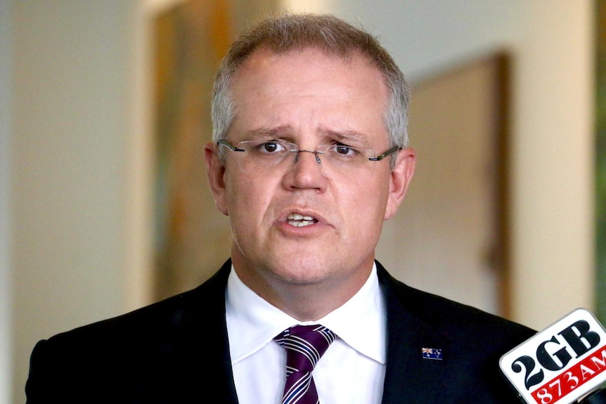 Headshot of Scott Morrison, looking straight ahead as he speaks during a press conference.