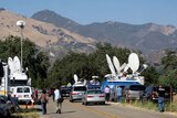 Television news trucks line the road outside the front gates of Neverland Ranch