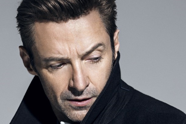 Actor Hugh Jackman poses in a black coat.