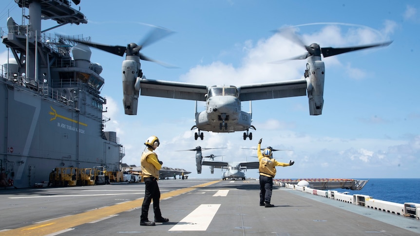 Osprey military aircraft taking off from landing helicopter assault vessel.