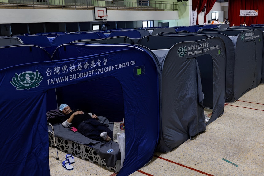 A man rests at a temporary reception center.