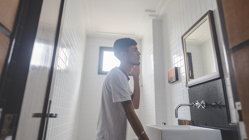 Young man looking in mirror