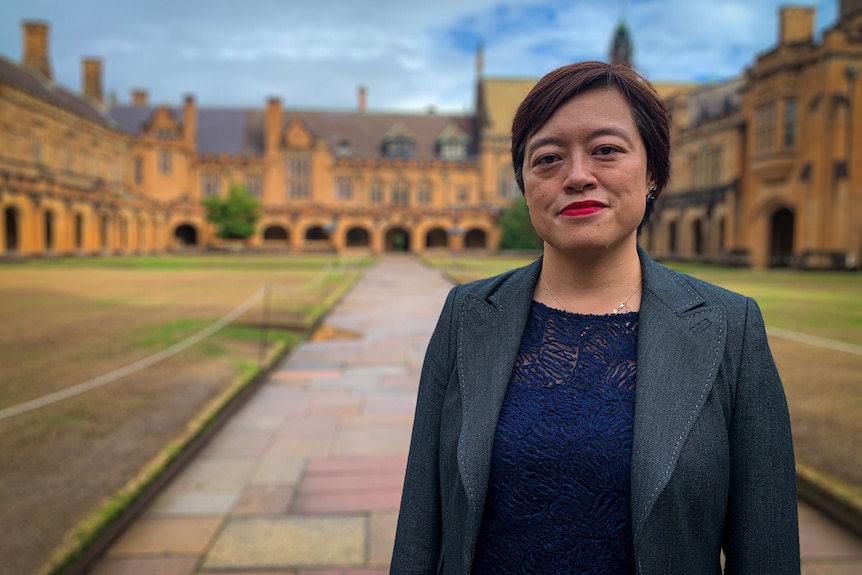 A woman stands on a uni campus.