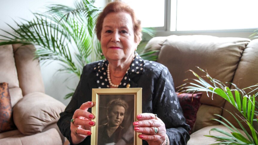 Elderly Jewish woman Yelena Gorodetsky holding photograph of her younger self.