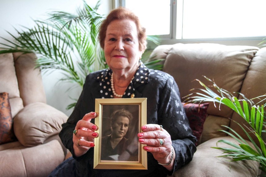 Elderly Jewish woman Yelena Gorodetsky holding photograph of her younger self.