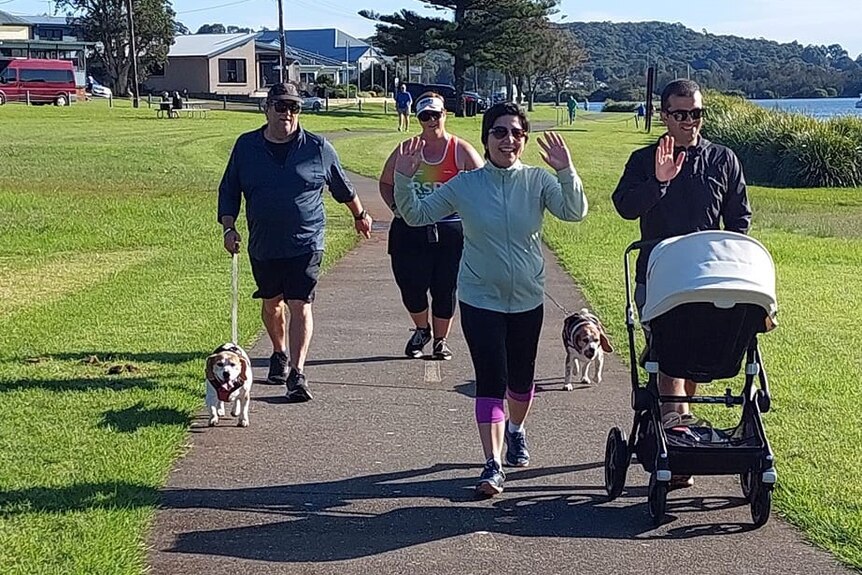 Hanieh and Rahmat push a pram while on a parkrun next to the water.
