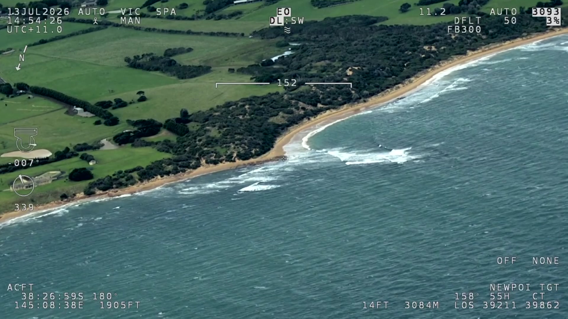 A birds-eye view of a segment of the Victorian coastline, featuring lush green fields. 
