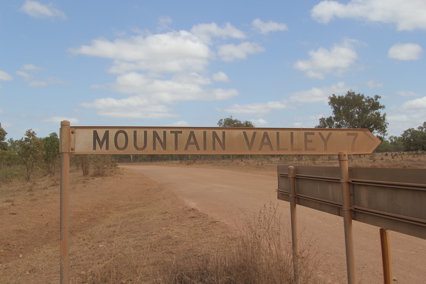 A dusty road sign reading "Mountain Valley 7".