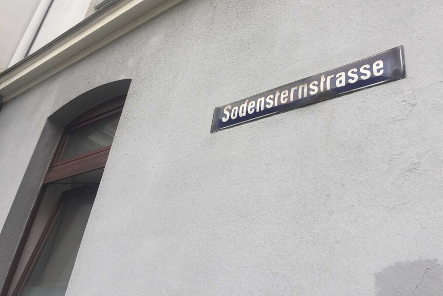 A street sign on the side of a building that reads "Sodenstrasse".