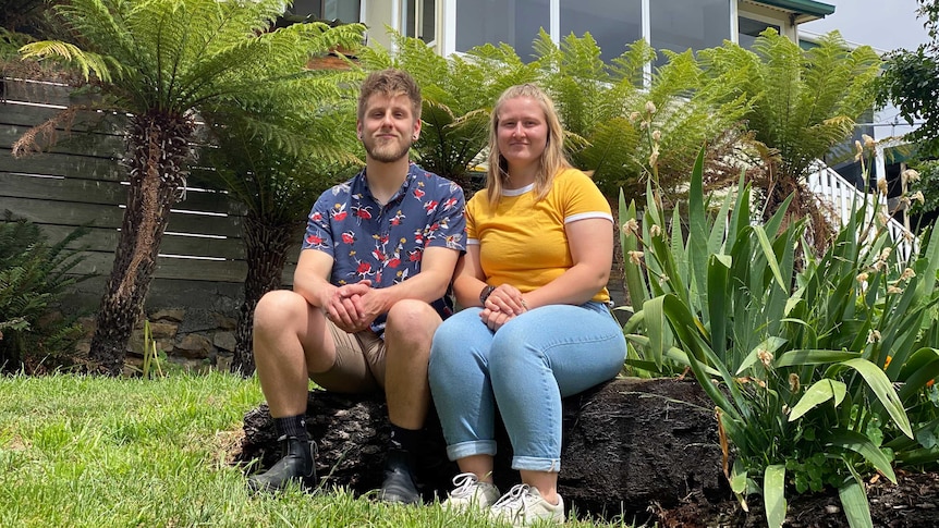 A girl and a boy sitting in the garden.