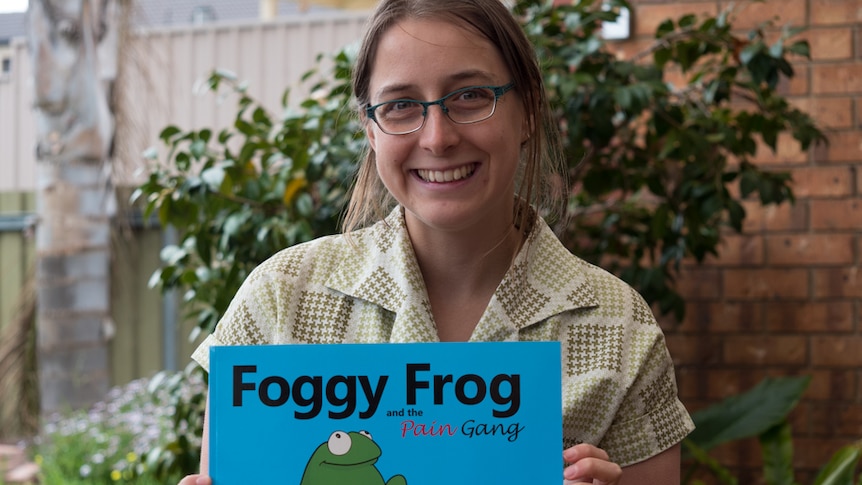 Megan Schartner with her Foggy Frog and the Pain Gang picture book.