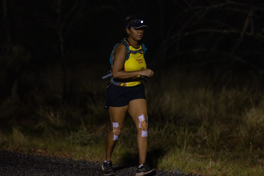 Cecilia Johns running through the desert in the dark.