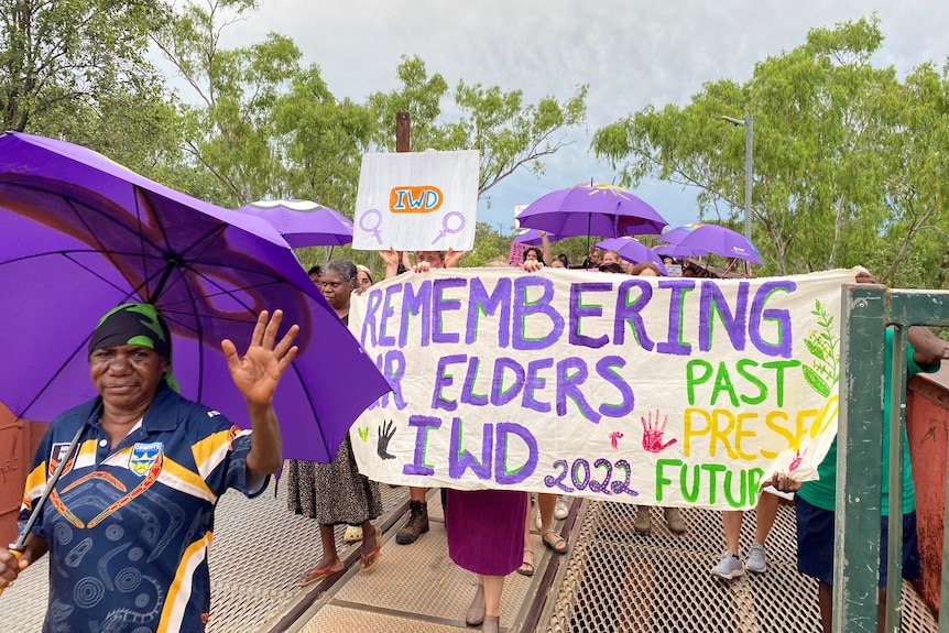 people holding a sign saying 'remembering our elders'