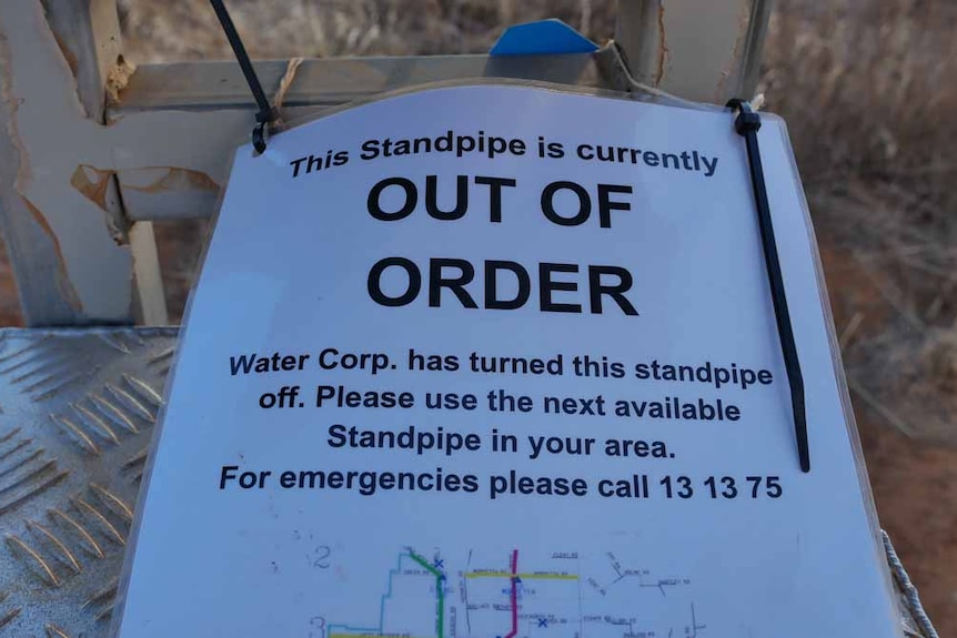 A printed sign saying 'Out of Order' rests on a metal structure.