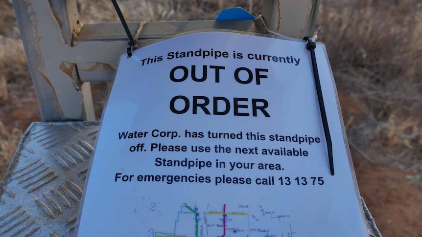 A printed sign saying 'Out of Order' rests on a metal structure.